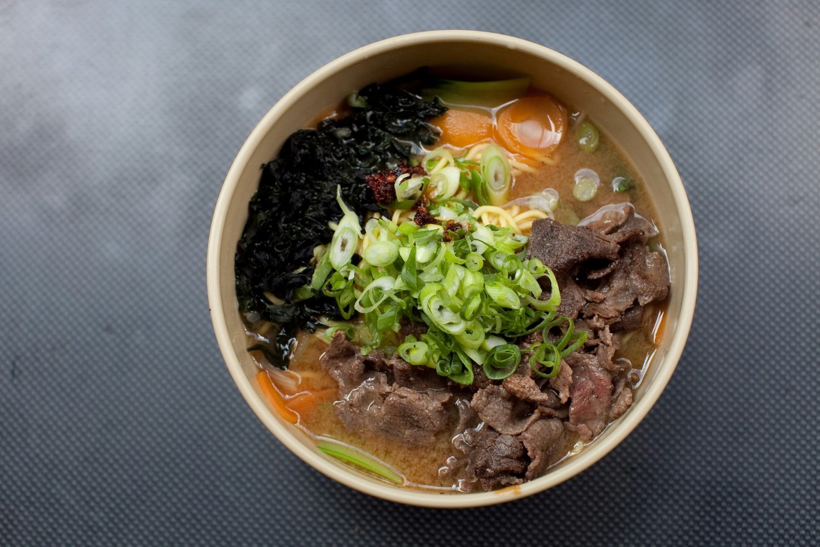 noodle soup with green leaf on white ceramic bowl